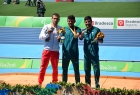 trzech mężczyzn stoi obok siebie, pokazując medale igrzysk paraolimpijskich, jeden z nich ubrany jest w biało-czerwony dres, pozostali w dresach zielono-niebieskich