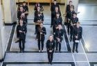 członkowie orkiestry Zespołu Pieśni i Tańca AGH „Krakus” ubrani w czarne uniformy stoją trzymając instrumenty