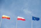 Flaga Małopolski, flaga Polski oraz flaga Unii Europejskiej na tle błękitnego nieba