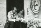 czarno-białe zdjęcie, mężczyzna i kobieta siedzą przed domem