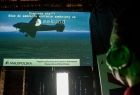 Na ekranie samolot wojskowy i opis wystawy