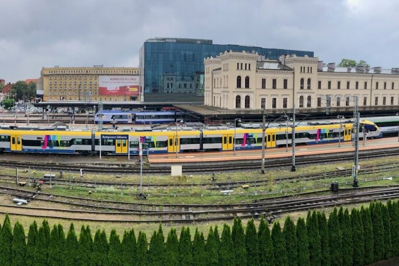 widok z góry na budynki kolejowe stacji Kraków Głowny, tory kolejowe i jadące po nich pociągi