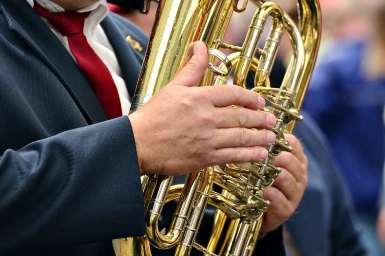 Mężczyzna trzyma w dłoniach instrument dęty