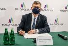 Marszałek województwa małopolskiego podpisujący protokół przekazania sprzętu i środków medycznych podarowanych Małopolsce przez partnerską Turyngię
