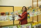 Marta Malec-Lech z zarządu województwa trzyma jedną z prac dzieci.