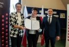 Marta Malec Lech z zarządu województwa stoi wraz z pozostałymi uczestnikami i trzyma podpisaną umowę.