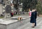 Iwona Gibas składa wieniec przed pomnikiem o kształcie Krzyża Virtuti Militari
