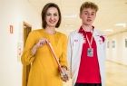 Marta Malec-Lech z zarządu województwa trzyma medal i stoi wraz z chłopcem, który już otrzymał stypendium.