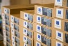 Zakupiony sprzęt komputerowy w kartonowych pudłach z naklejkami informującymi o dofinansowaniu ze środków unijnych