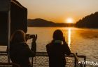 Dwie osoby patrzą na zachód słońca nad jeziorem