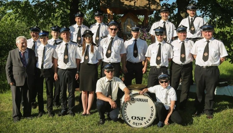 Orkiestra Dęta OSP Łękawica pozuje do zdjęcia w mundurach galowych.