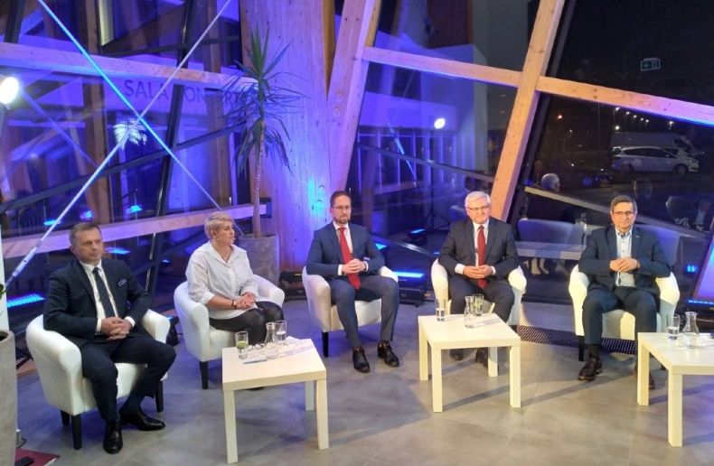 Uczestnicy debaty w Tarnowie siedzą na fotelach w rzędzie