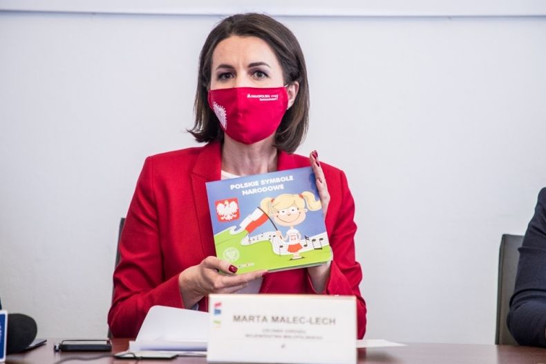 Marta Malec-Lech z zarządu województwa pokazuje książeczkę dla dzieci.