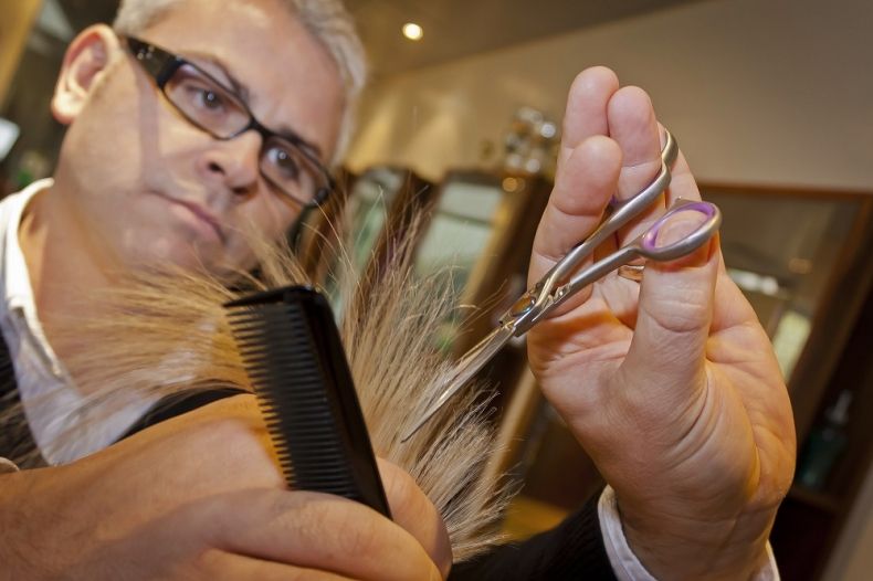 Fryzjer obcina włosy nożyczkami