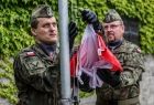 Żołnierze wciągają na maszt flagę Polski.