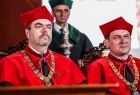 Władze Uniwersytetu Jagiellońskiego-dwaj mężczyźni, w czerwonych szatach, siedzą podczas uroczystości.