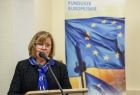 Radna Marta Mordarska w trakcie przemowy, w tle widać flagę unijną.
