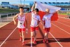 Trójka zawodników stoi na bieżni trzymając flagę Polski