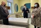 Wicemarszałek Łukasz Smółka ogląda salę z łóżkami w szpitalu w towarzystwie kobiety i mężczyzny. Na ścianach widoczne kolorowe wzory.