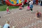 Dziewczynka pisze kredą na chodniku "Małopolski Zielony Tydzień 2022"