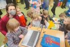 Marta Malec-Lech z zarządu województwa pokazuje nowego laptopa dzieciom.