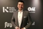Wicemarszałek Łukasz Smółka stoi na tle ścianki z napisem Radio Kraków Kultura.