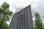 Widok na grybowski Pomnik poległych w II wojnie światowej. Zbliżenie na herb Polski na postumencie