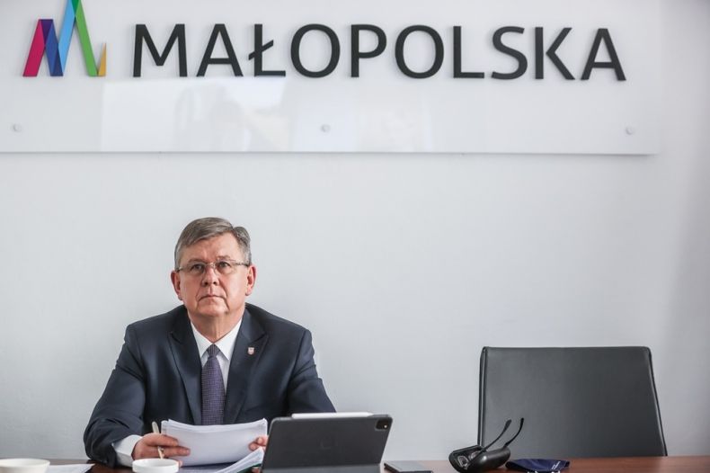 Marszałek Witold Kozłowski siedzi podczas zarządu województwa. W tle widoczny napis: Małopolska.