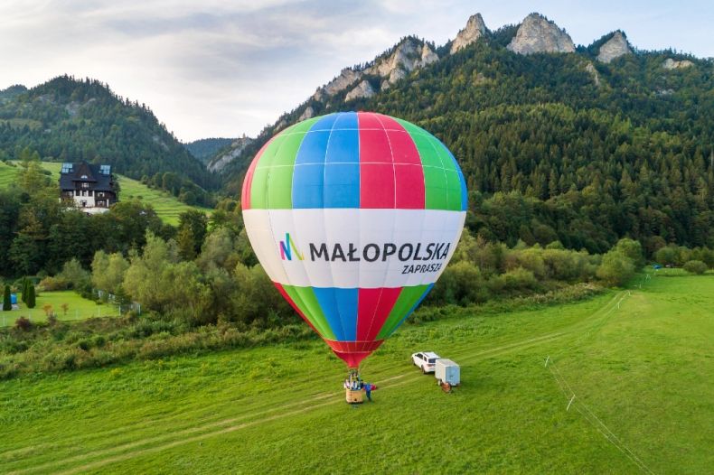 Balon z napisem "Małopolska" na tle zieleni i gór