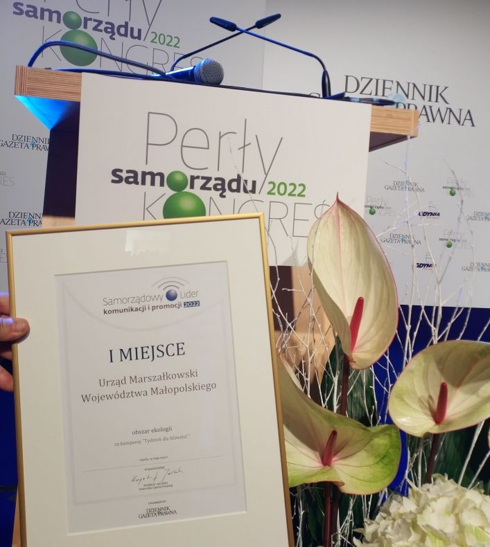 Dyplom ustawione na tle ekranu z napisem Perły Samorządu 2022