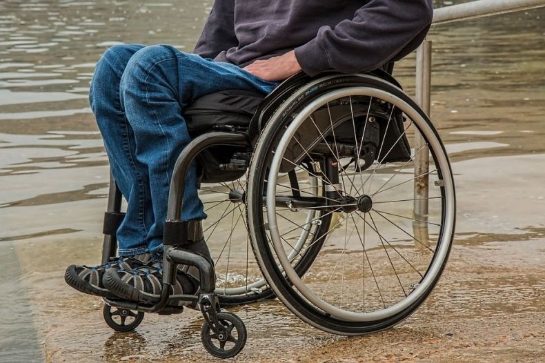 Osoba siedząca na wózku inwalidzkim.