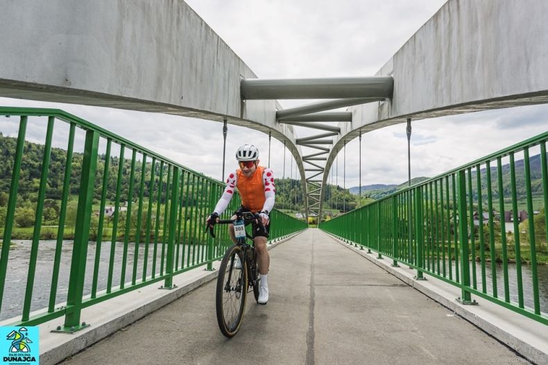 kolarz przejeżdża most na Dunajcu