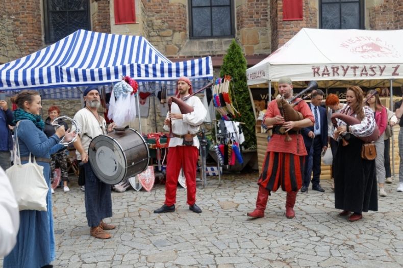 Pięcioosobowy zespół muzykantów w średniowiecznych strojach.