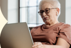 Kobieta w wieku senioralnym obsługująca laptop