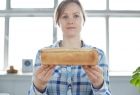 Kobieta prezentująca bochenek chleba.