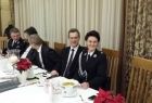 Grupa osób siedzi przy stole, wśród nich przewodnicząca sejmiku Urszula Nowogórska w mundurze strażackim.
