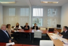 zdjęcie przedstawia osoby siedzące przy stole ułożonym w literę L
