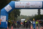 dmuchana niebieska brama startowa z logami sponsorów i patrnerów. Poniżej na rowerach czekaja na start dzieci i najstarsi uczestnicy zawodów