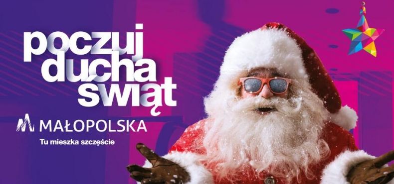 Plakat z napisem po lewej: Poczuj ducha świa. małopolska. tu mieszka szczęście. Po prawej św. Mikołaj z dłońmi wyciągniętymi do przodu