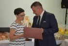 Radny Adam Kwaśniak wręcza kobiecie grawerton.
