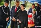 Przewodnicząca Urszula Nowogórska stoi przed mikrofonem w gronie strażaków.