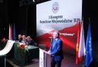 Grzegorz Biedroń stoi przy mównicy. W tle ekran z napisem I Kongres Sejmików Województw RP.