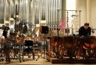 Scena, na której znajduje się b dużo instrumentów perkusyjnych i człowiek, który gra na jednym z nich