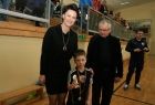 Trzy osoby stoją na parkiecie hali sportowej. Pierwsza z lewej przewodnicząca sejmiku U. Nowogórska. Obok niej chłopiec w stroju sportowym trzymający puchar.