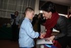 Przewodnicząca sejmiku Urszula Nowogórska wręcza nagrodę małemu chłopcu.