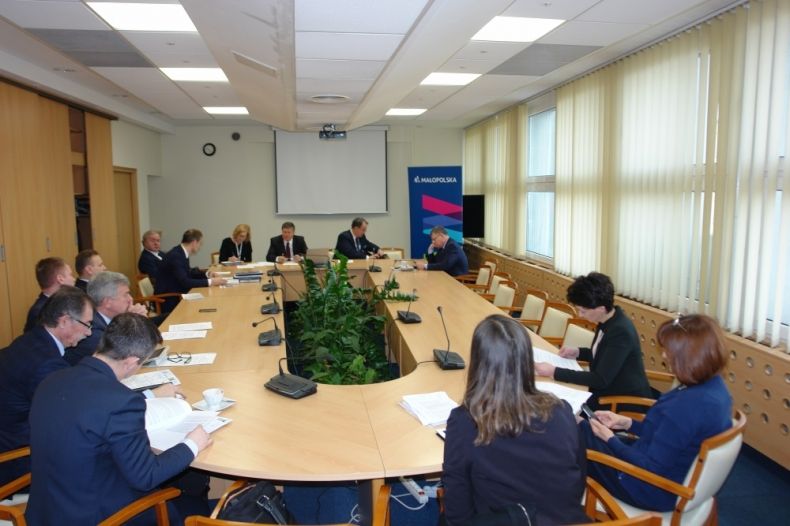 Grupa osób siedzących przy owalnym stole. Po prawej stronie przewodnicząca sejmiku Urszula Nowogórska.