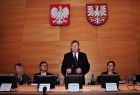 cztery osoby za stołem prezydialnym, Marszałek Witold Kozłowski przemawia na stojąco