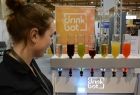 automat do robienia drinków i kobieta go prezentująca