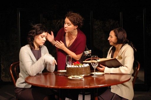 Zdjecie przedstawia 3 kobiety siedzące przy stole. Spektakl Wszystko o kobietach w wykonaniu Teatru Ludowego z Krakowa.