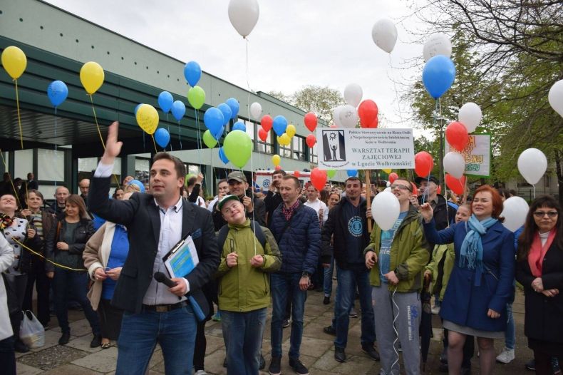 Zdjęcie przedstawia uczestników wydarzenia trzymających balony.